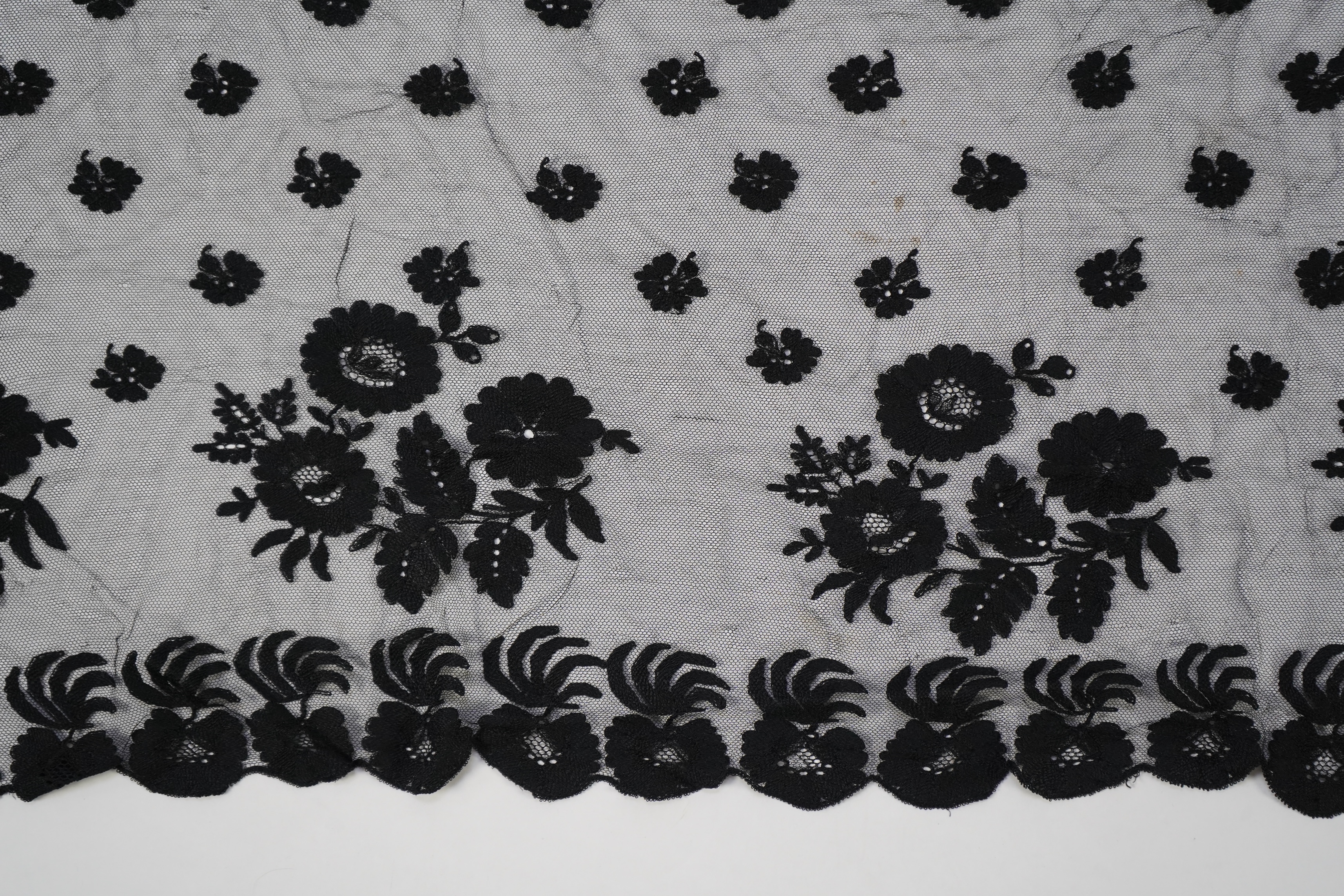 A collection of mixed machine lace: a black lace stole, two black veils, a sample of Japanese brocade, a length of metallic ribboning and various items of cream lace, ribboning 230cm long. Condition - variable poor to fa